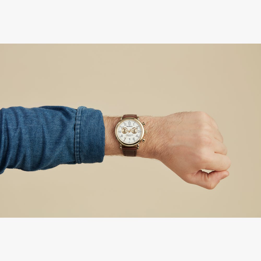 Champagne dial watch with leather band.