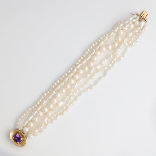 Pearl strand bracelet with amethyst centerpiece.