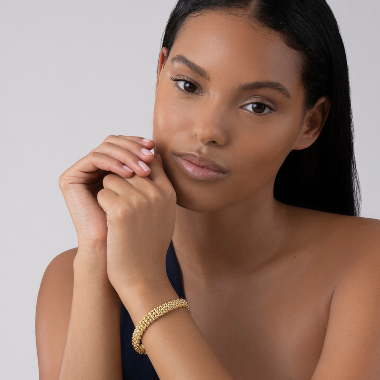 18K gold textured bracelet on wrist.