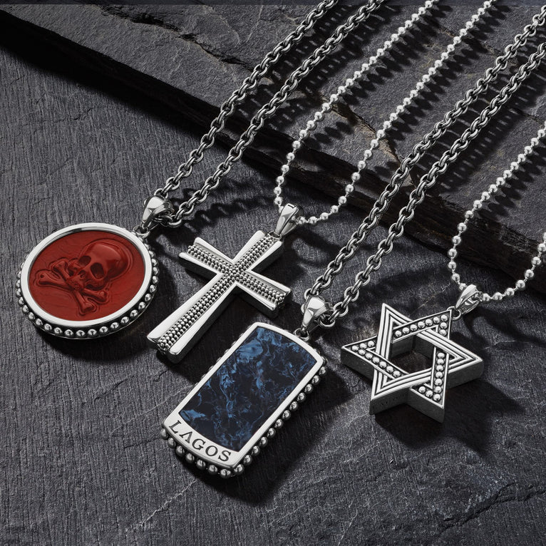 Sterling silver pendant necklaces on dark surface.