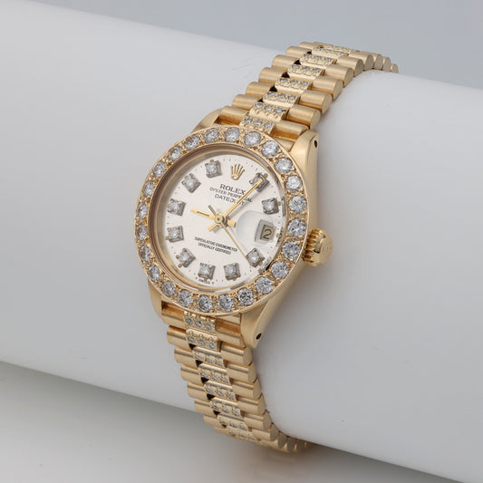 Gold Rolex watch with diamond bezel.