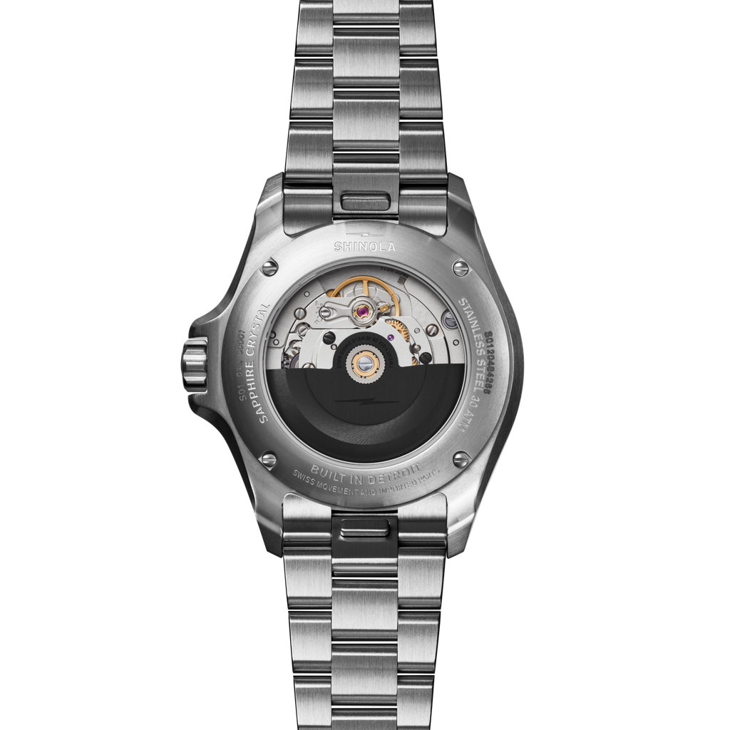 Stainless steel automatic watch with visible movement.