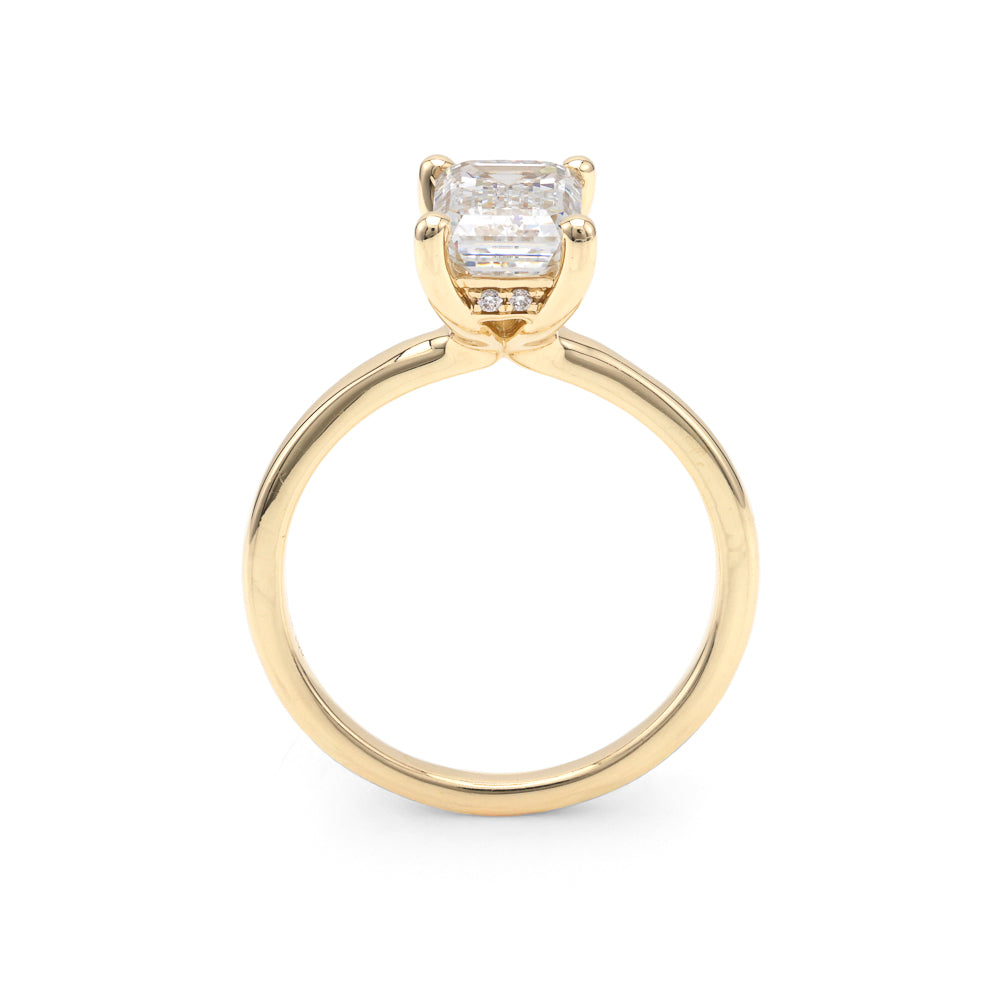 Yellow gold ring with emerald-cut diamond.