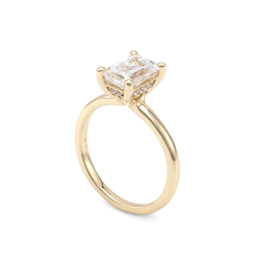 Yellow gold ring with emerald-cut diamond.