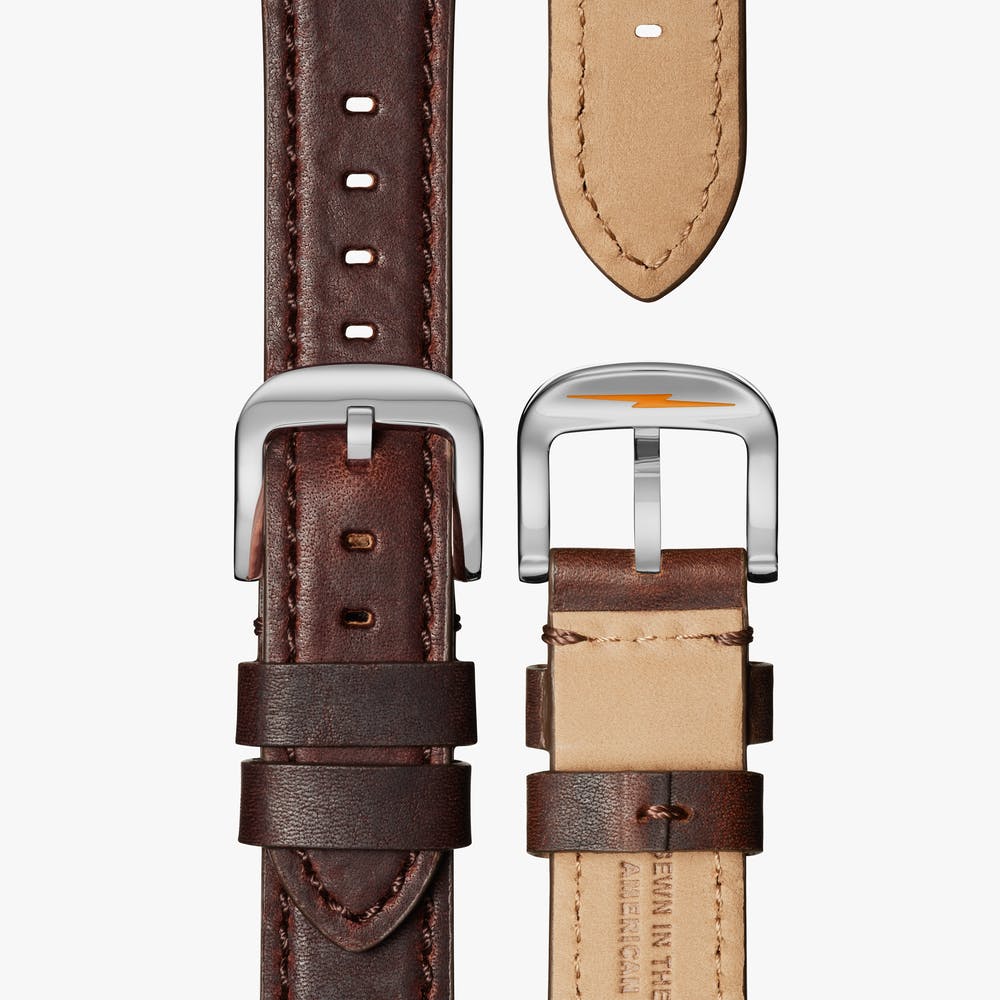 Brown leather watch strap with silver buckle.