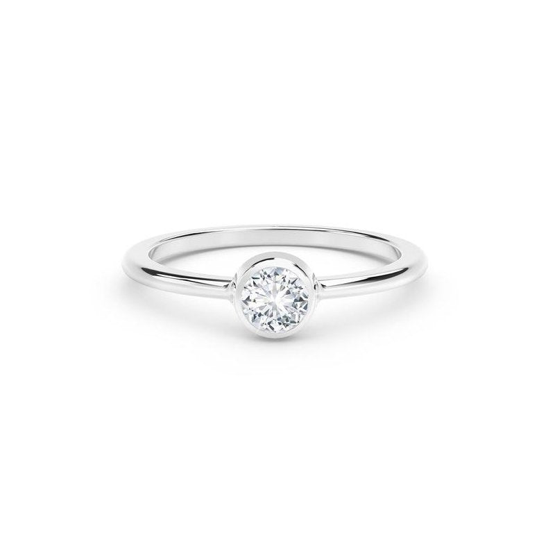 White gold ring with round diamond centerpiece.