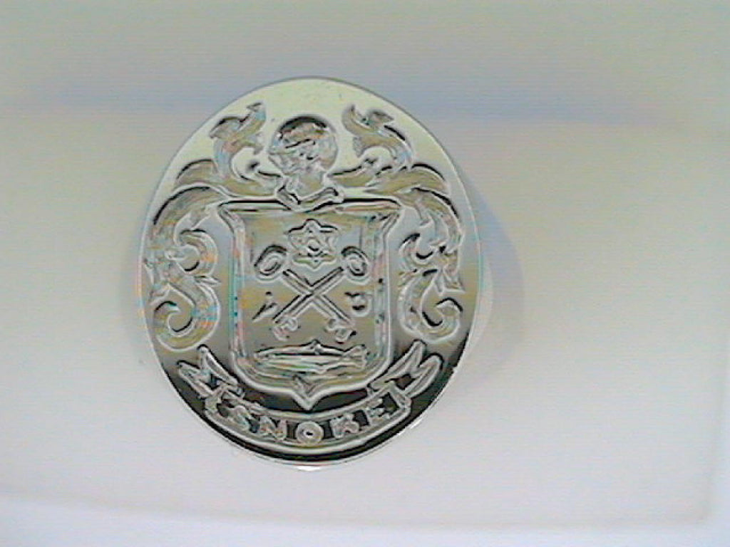 White gold ring with intricate crest design.