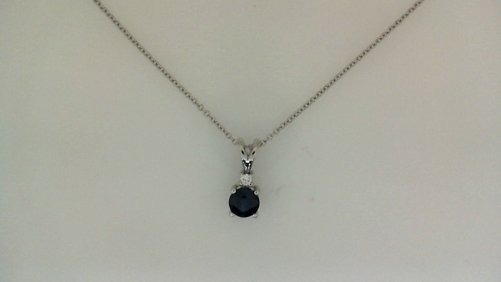 Round sapphire pendant on cable chain.