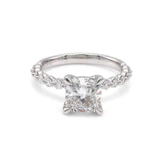 Cushion diamond ring with round accents.