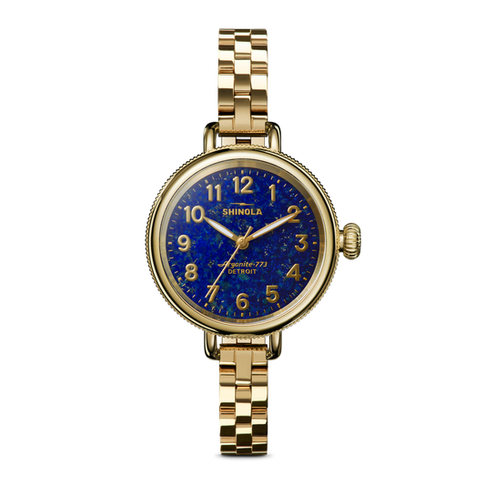Gold watch with blue dial, stainless steel band.