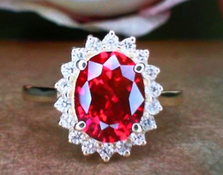 Oval ruby ring with diamond halo.