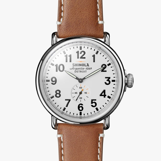 Silver round watch with brown leather band.