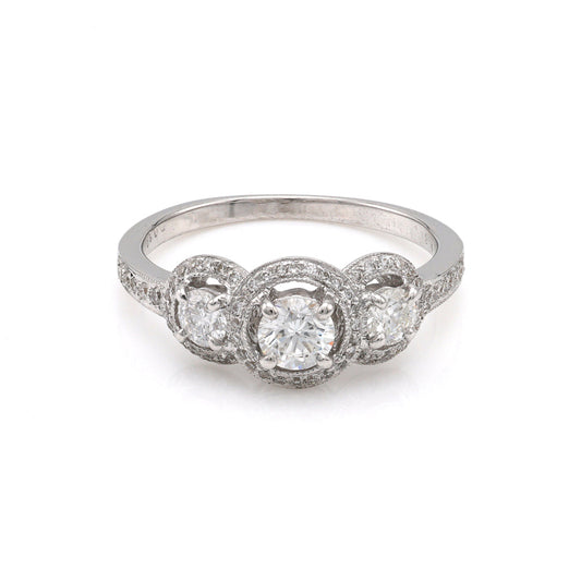 Three-stone diamond halo ring in white gold.
