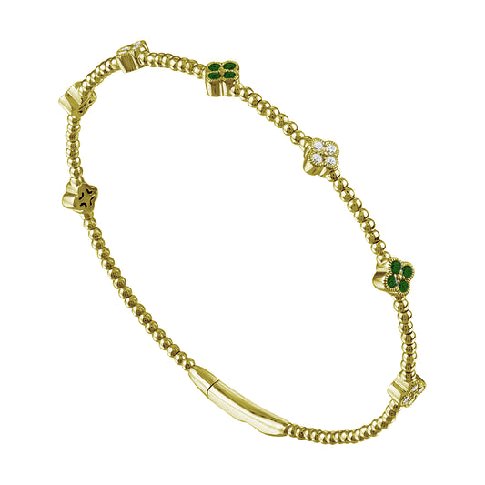 Yellow gold bangle with emeralds and diamonds.