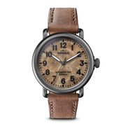 Tan dial, leather band, stainless steel watch.