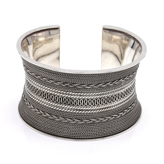 Sterling silver cuff with intricate patterns.