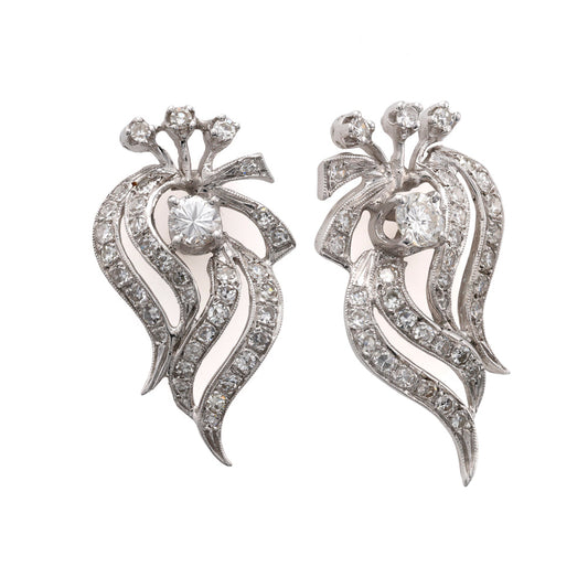 Diamond swirl drop earrings in white gold.