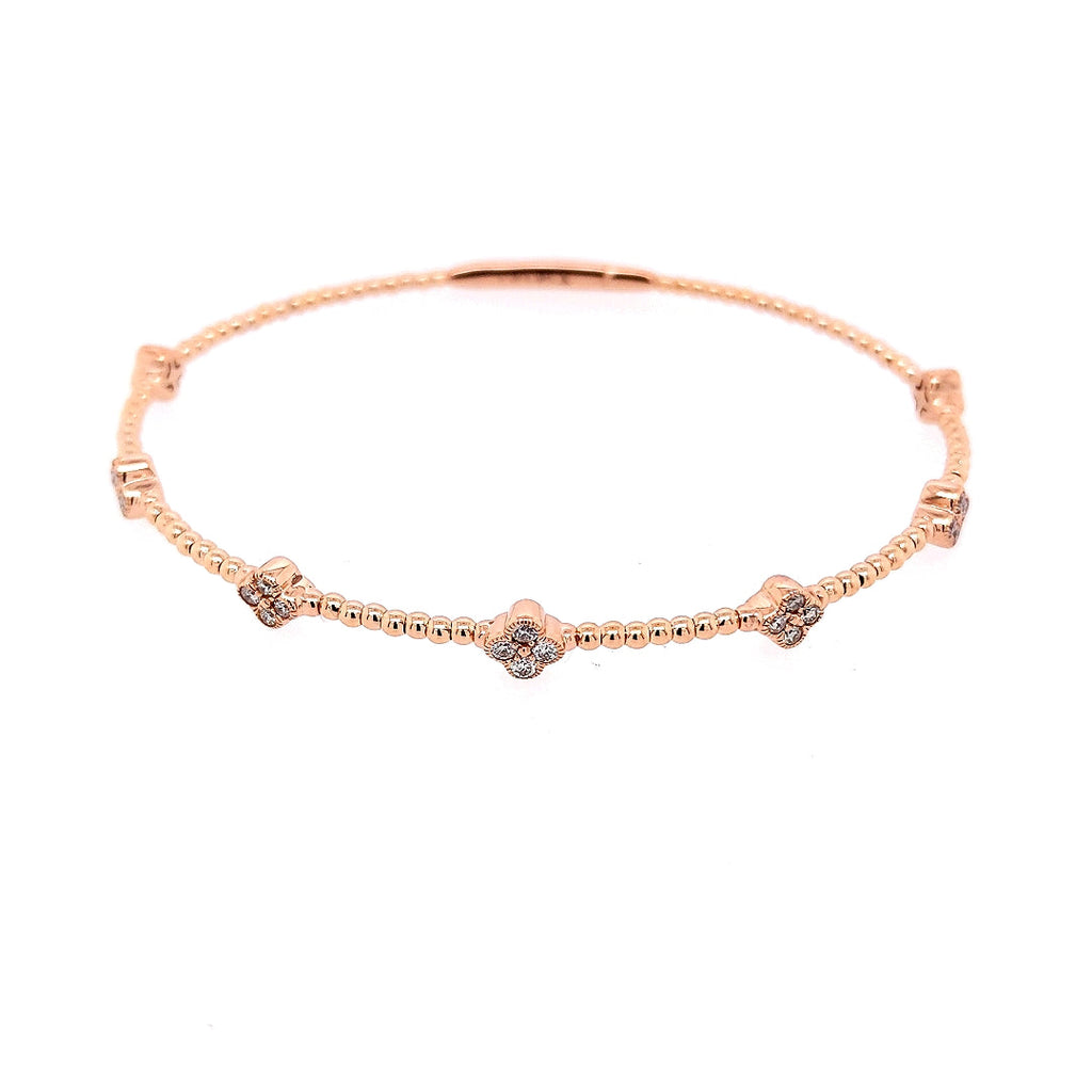 Rose gold bangle with round diamond clusters.