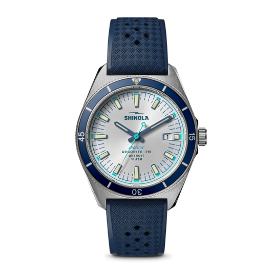 Silver dial, blue bezel, rubber strap watch.