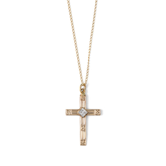 Gold cross necklace with central diamond.