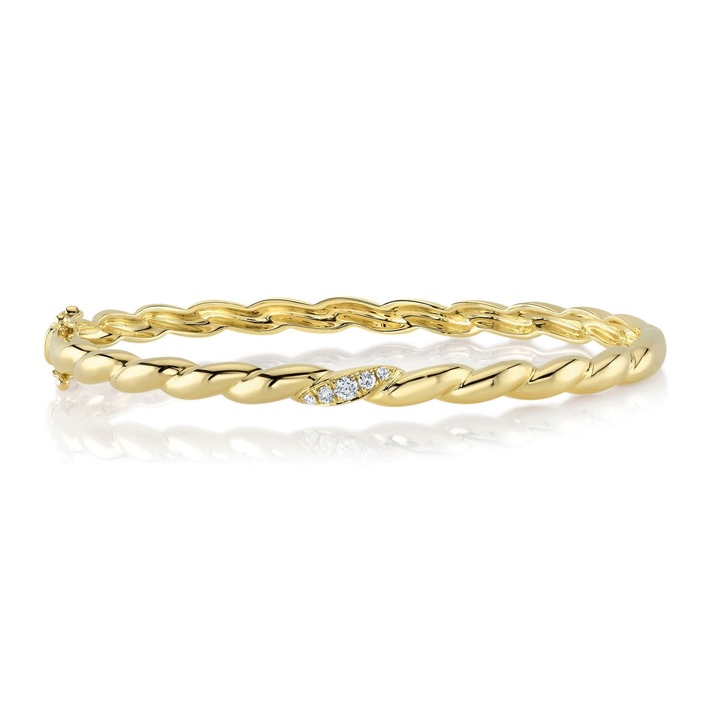 Twisted gold bangle with diamond accents.