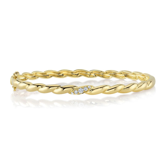 Twisted gold bangle with diamond accents.