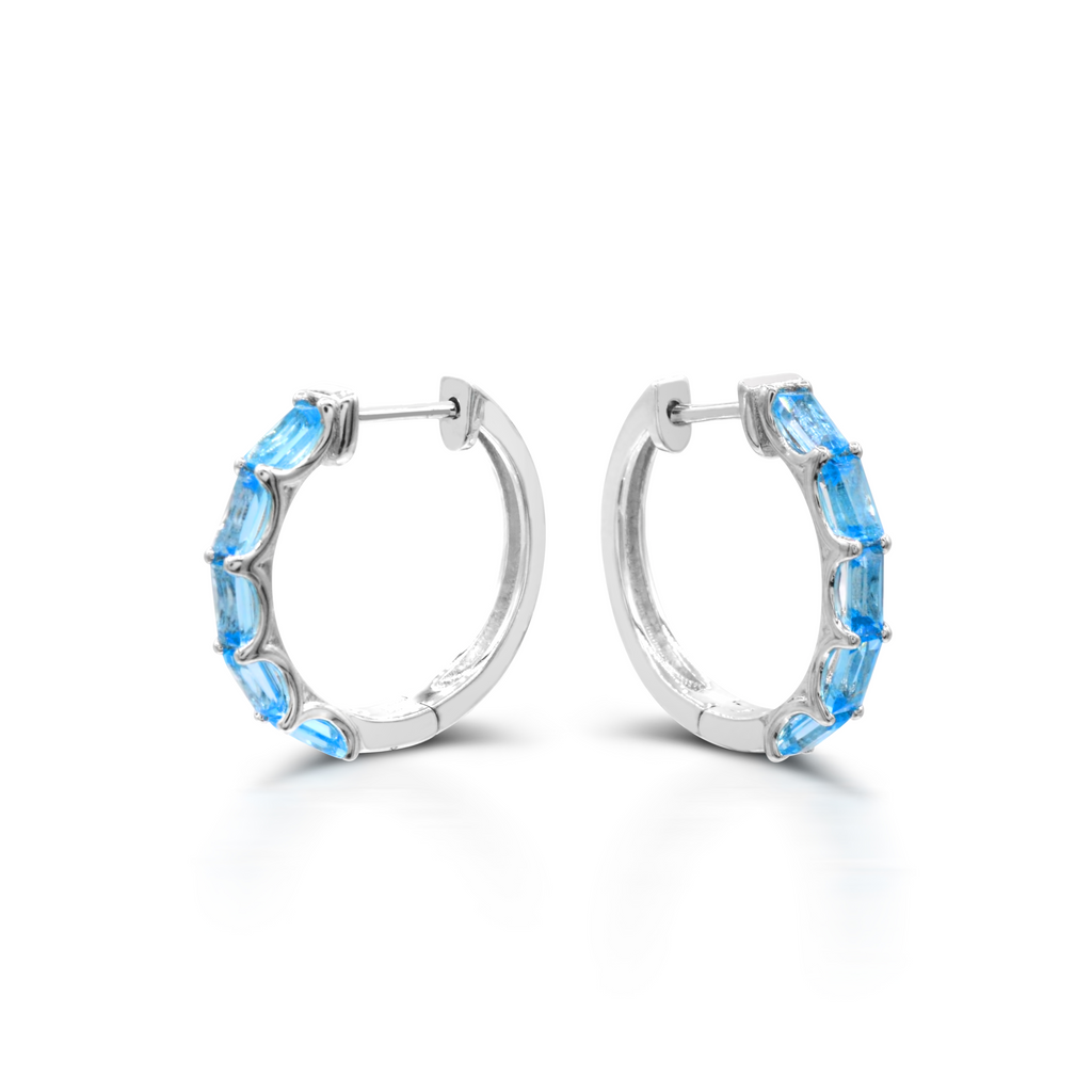 Sterling silver hoop earrings with blue topaz gemstones.