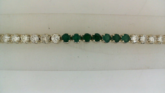 Emerald and diamond tennis bracelet in gold.