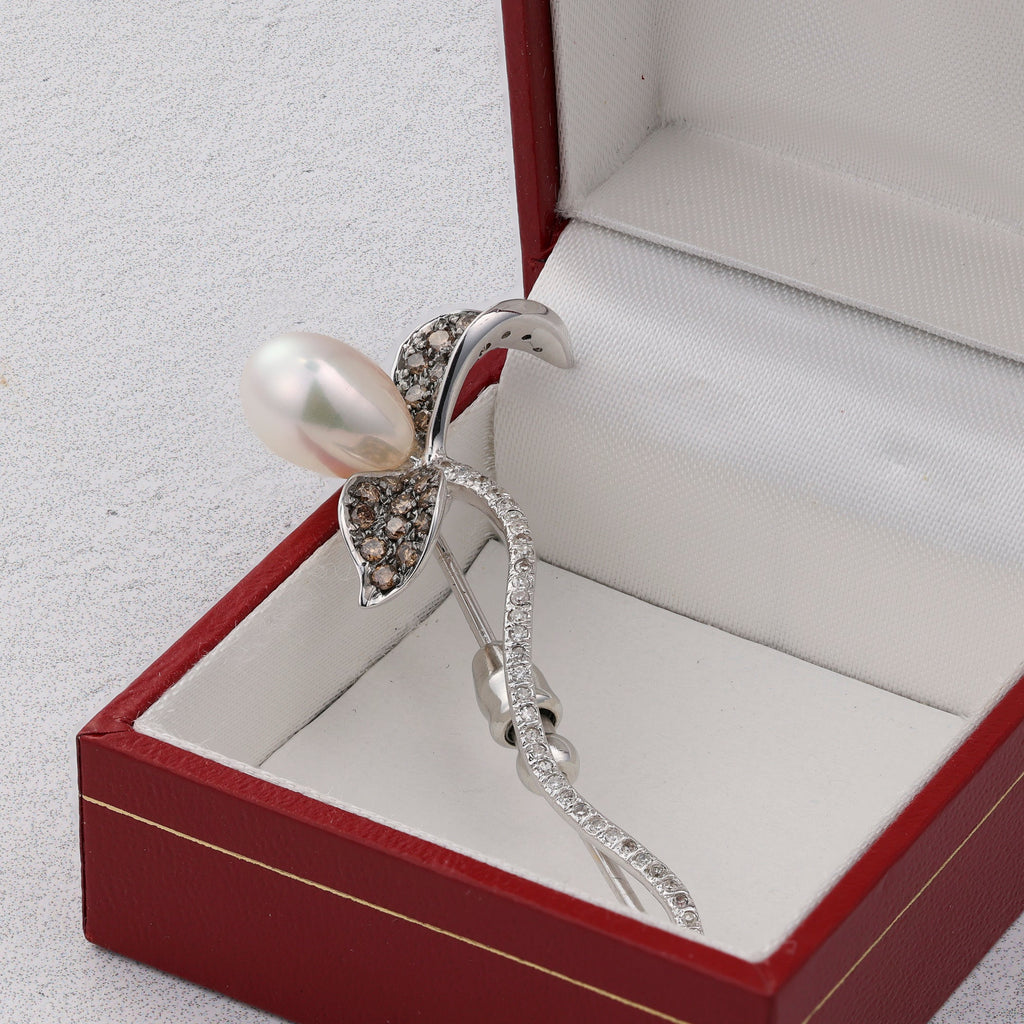 Diamond and pearl flower pin in box.