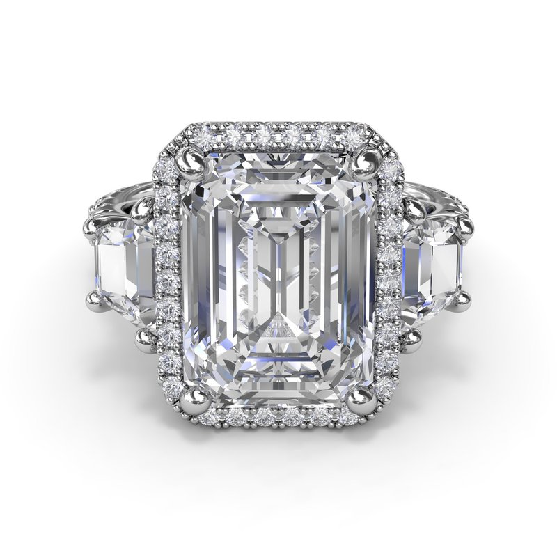 Halo three-stone diamond ring in white gold.