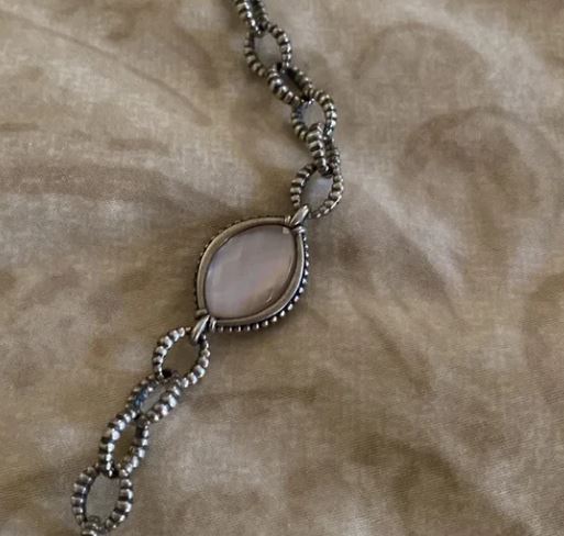 Sterling silver necklace with oval gemstone pendant.