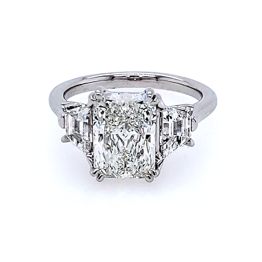 Radiant-cut diamond ring with trapezoid side stones.