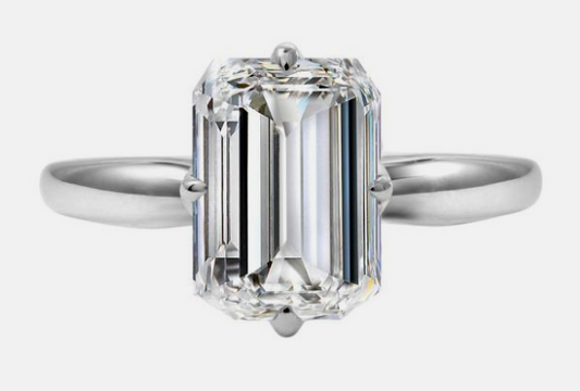 Emerald-cut diamond solitaire ring in white gold.