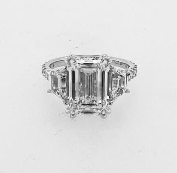 Three-stone emerald-cut diamond engagement ring.