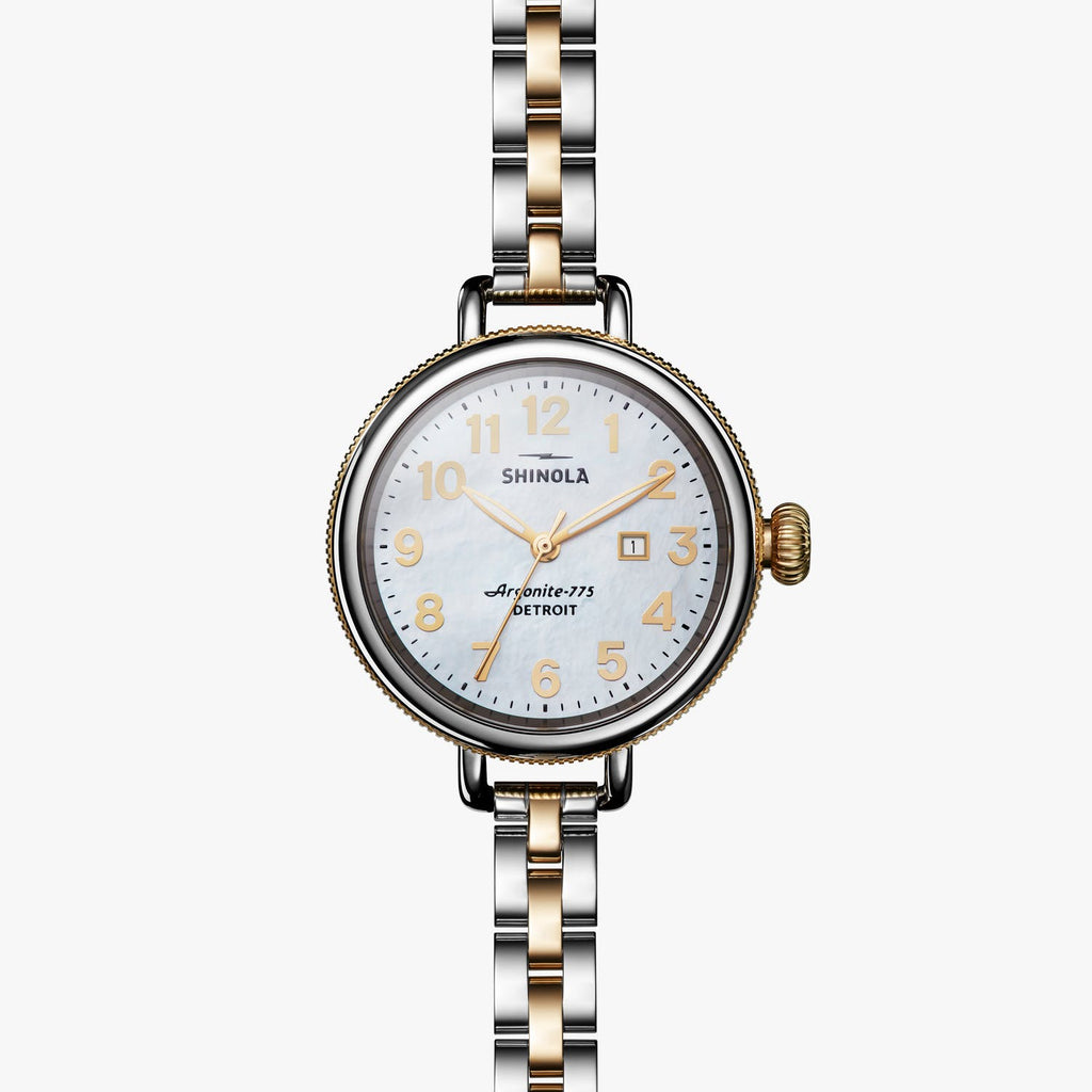 Gold-accented watch with mother-of-pearl dial.