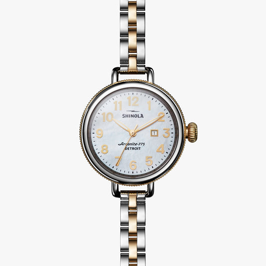 Gold-accented watch with mother-of-pearl dial.