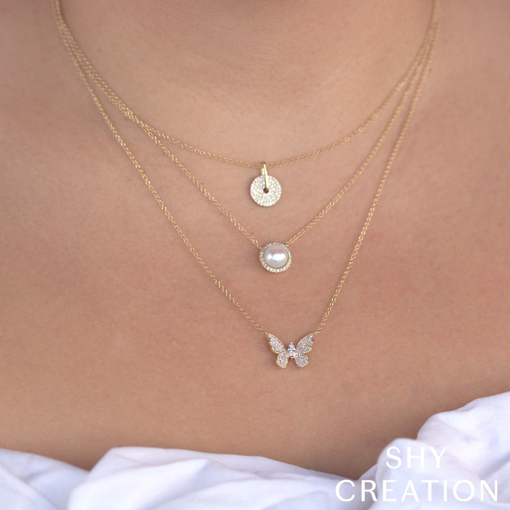 Diamond butterfly pendant on yellow gold chain.