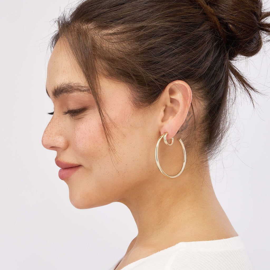 14K yellow gold hoop earrings on model.