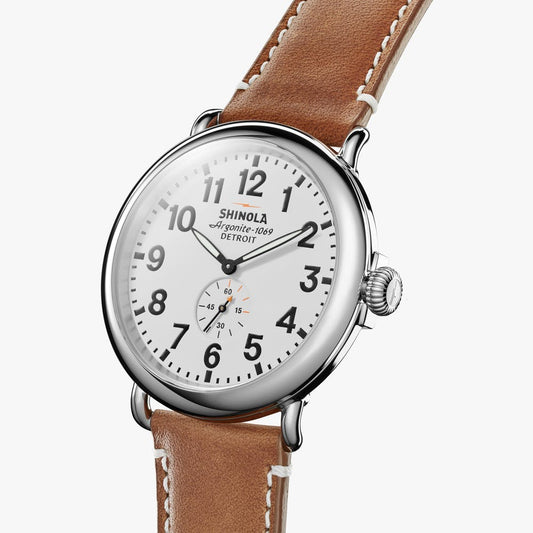 Silver round watch with brown leather band.