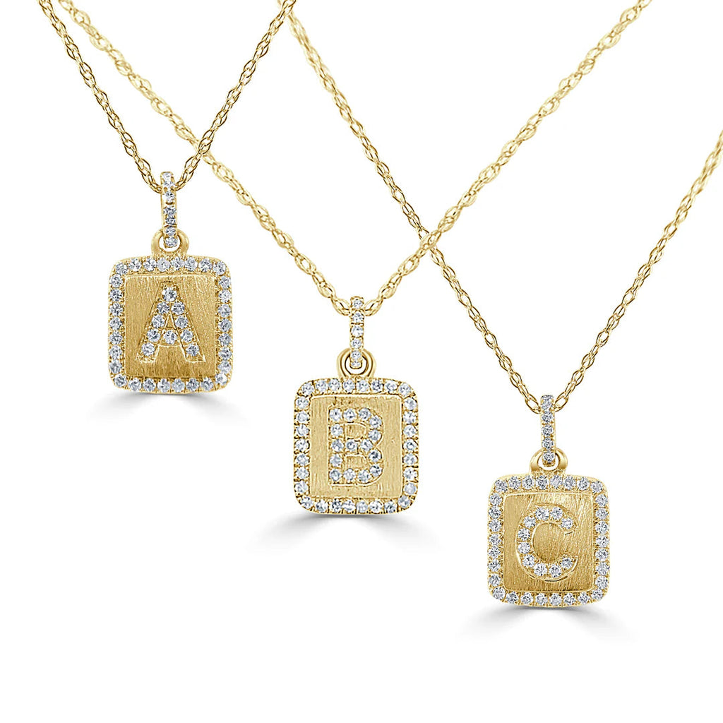 Gold necklaces with diamond letter pendants.