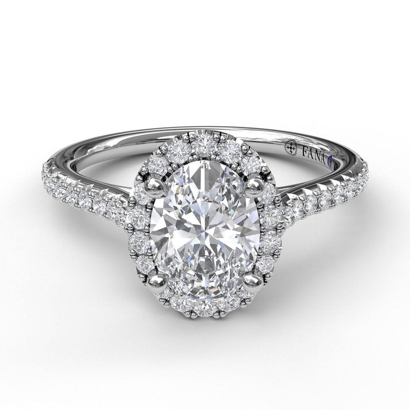 Oval diamond halo engagement ring in white gold.