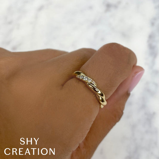 Yellow gold diamond twist band on hand.