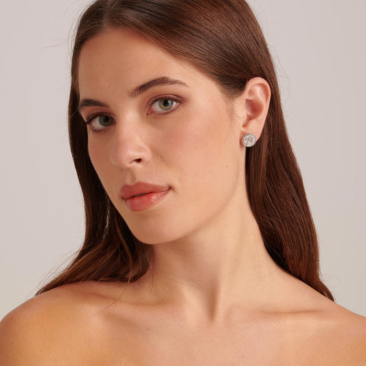 Stainless steel white stud earrings worn.