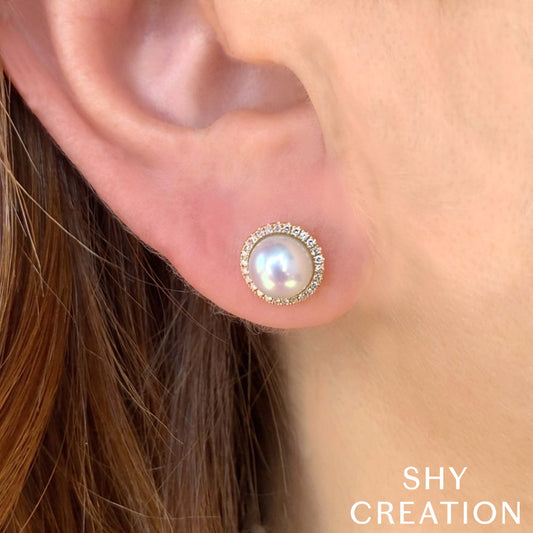 Pearl earrings with diamond halo in gold.
