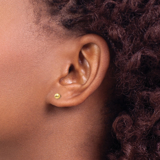14K yellow gold stud earrings on ear.