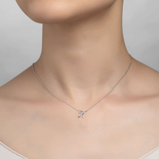 Simulated diamond initial necklace on neck.