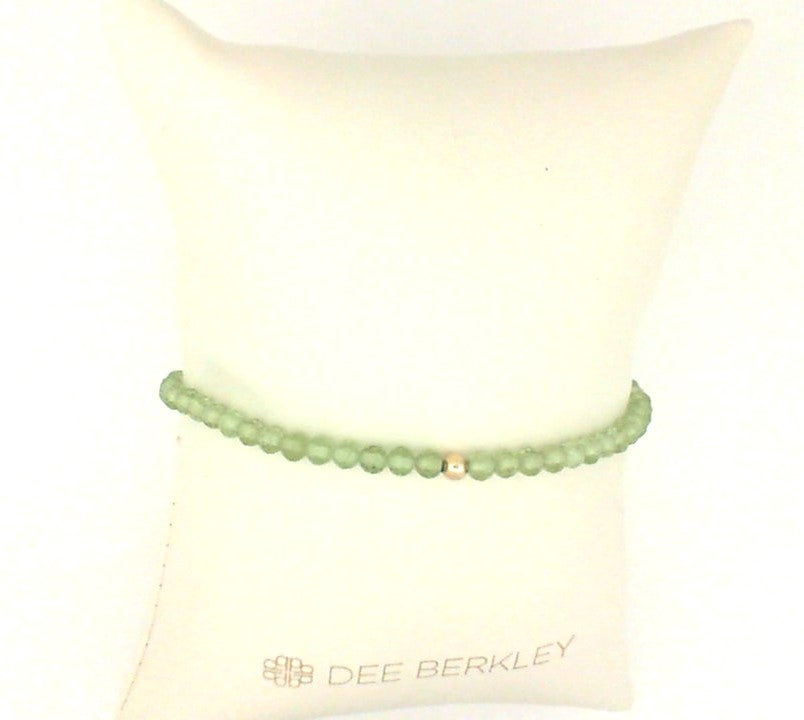 Peridot stretch bracelet with gold accent.