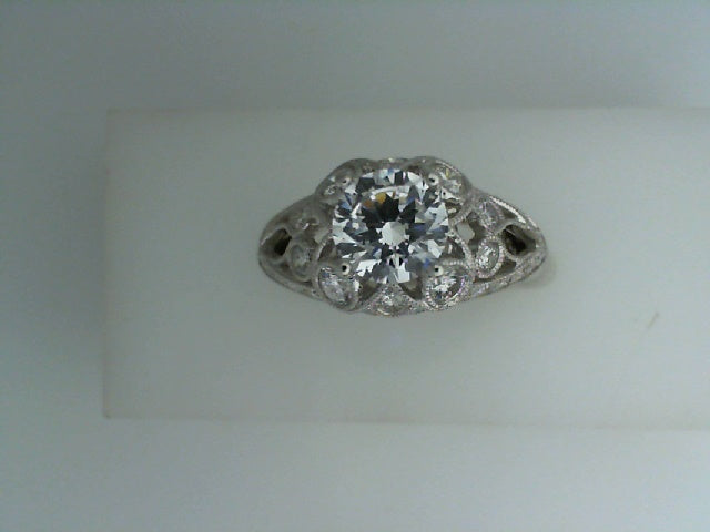 Intricate white gold ring with central diamond.