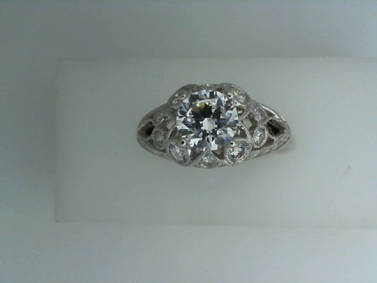 Intricate white gold ring with central diamond.