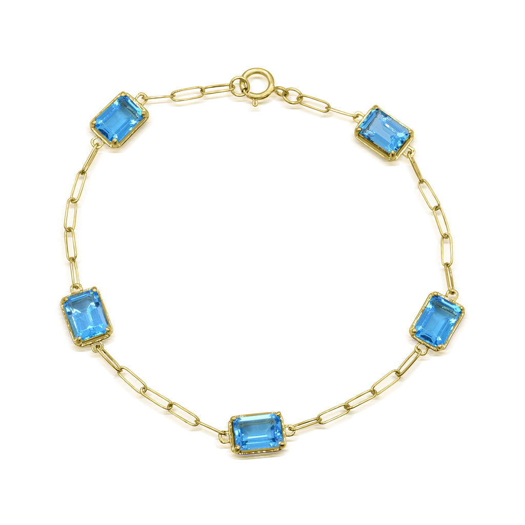 Yellow gold bracelet with blue topaz gemstones.